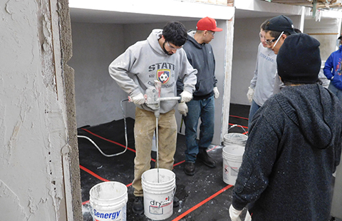 Tulalip Vocational Training Center students practicing drywall techniques – mixing mud.
