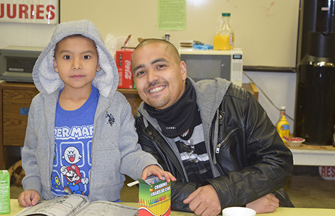 TVTC student with child having fun coloring at a family day visit of the facility.