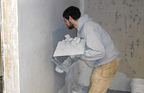 Tulalip Vocational Training Center student practicing drywall techniques.